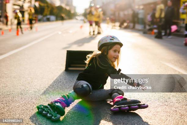 kleines mädchen fiel nach sprung mit rollschuhen zu boden - skate fail stock-fotos und bilder