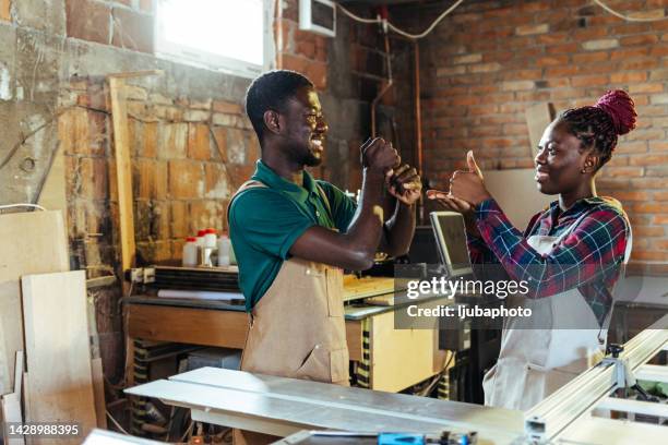 carpenters in workshop having conversation using sign language - deafness stock pictures, royalty-free photos & images