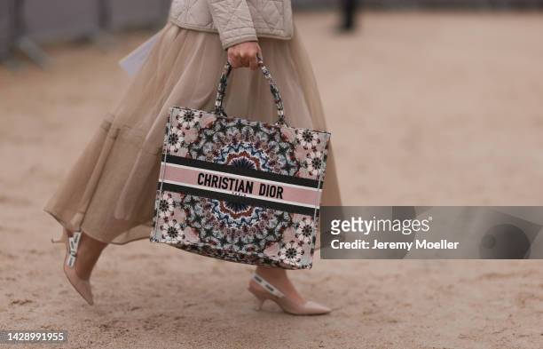 Fashion week guest seen wearing a dior look with a dior book tote bag and heels by dior, outside Christian Dior during Paris Fashion Week on...