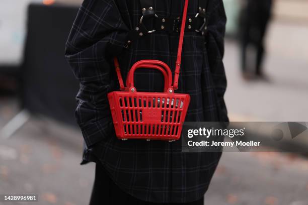 Guest is seen wearing black checked oversize shirt, a red Balenciaga basket bag and a black pleated long skirt, outside Undercover, during Paris...