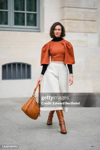 Guest wears a black turtleneck / long sleeves cropped top, a camel puffy short sleeves cropped blouse, high waist white latte linen oversized wide...