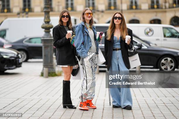 Guest wears black sunglasses, gold earrings, a gold chain necklace, a pale gray wool pullover, a black blazer jacket, a black shiny leather...