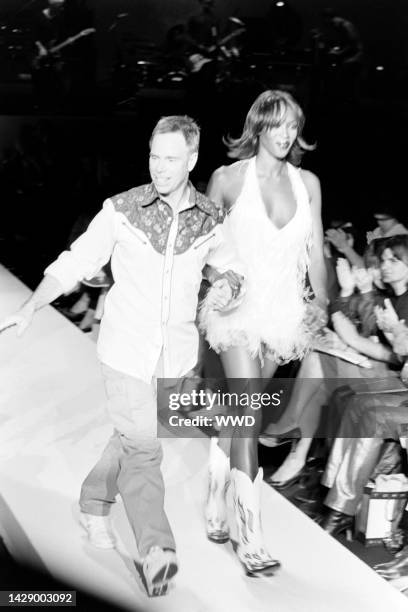 Designer Tommy Hilfiger walks the runway at close of show with model Naomi Campbell.