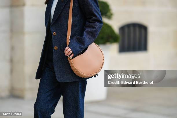 Guest wears a white turtleneck cropped wool pullover from Courreges, a navy blue denim blazer jacket, matching navy blue denim flared pants, a beige...