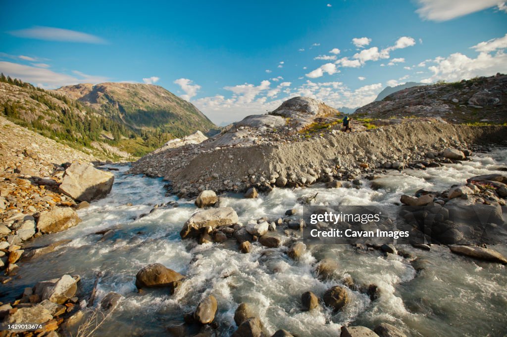 A hiker on the other side of a rushing river, Garibaldi Provincial Park