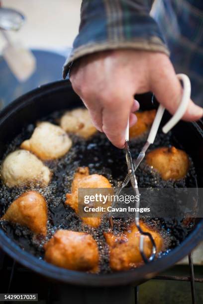 man preparing traditional oliebollen dutch doughnuts, langley, british columbia, canada - oliebol bildbanksfoton och bilder