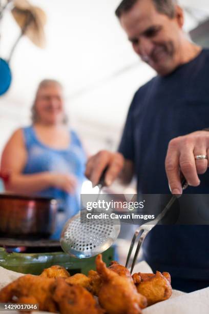 man preparing traditional oliebollen dutch doughnuts, langley, british columbia, canada - oliebollen stockfoto's en -beelden