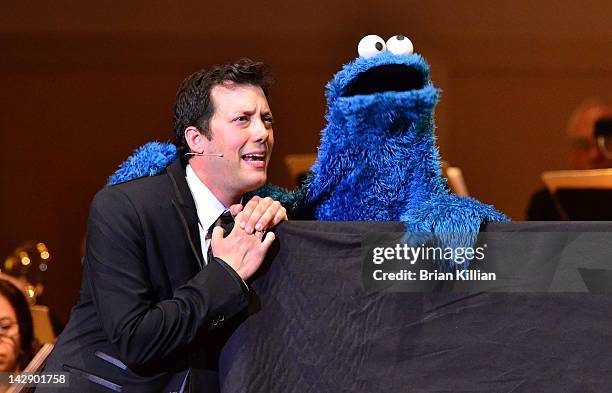 Host John Tartaglia performs with the Cookie Monster during The New York Pops Present "Jim Henson's Musical World" at Carnegie Hall on April 14, 2012...