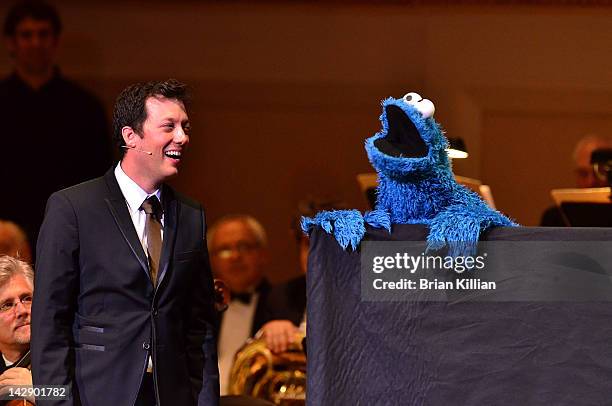 Host John Tartaglia performs with the Cookie Monster during The New York Pops Present "Jim Henson's Musical World" at Carnegie Hall on April 14, 2012...