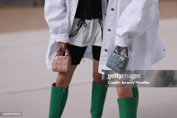 Ami is seen wearing a white t-shirt, black laces corset top, a white oversized denim jacket, black cycling shorts, a beige shiny leather micro Lady...