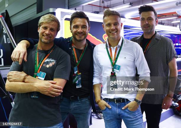 Westlife pose for a photo outside the Red Bull Racing garage during practice ahead of the F1 Grand Prix of Singapore at Marina Bay Street Circuit on...