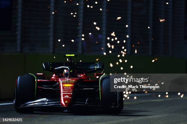 Sparks fly behind Carlos Sainz of Spain driving the Ferrari F1-75 during practice ahead of the F1 Grand Prix of Singapore at Marina Bay Street...