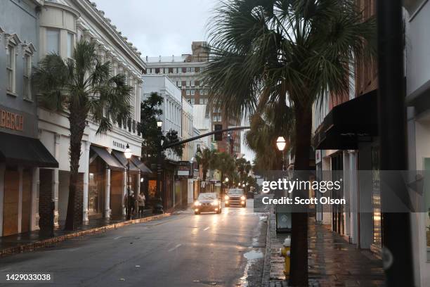 Cars drive through a nearly-deserted historic district as the city prepares for Hurricane Ian to make landfall on September 30, 2022 in Charleston,...