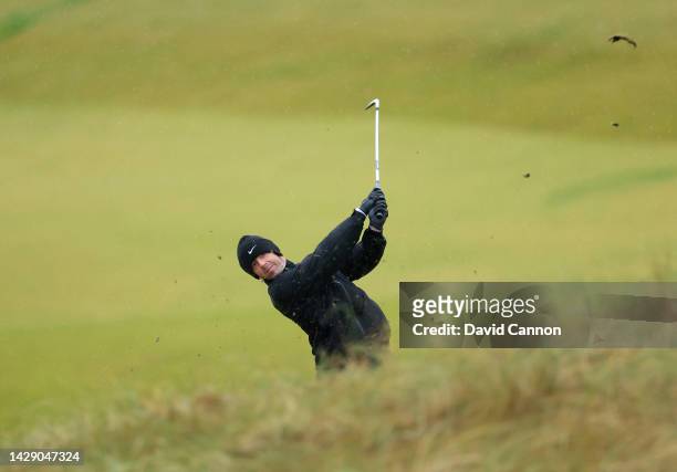 Rory McIlroy of Northern Ireland plays his second shot on the third hole wearing two golf gloves in the wet weather during Day Two of the Alfred...