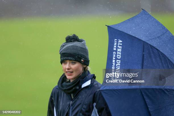 Kathryn Newton the Amewrican actress shelters behind an umbrella in teh poor weather during Day Two of the Alfred Dunhill Links Championship at...