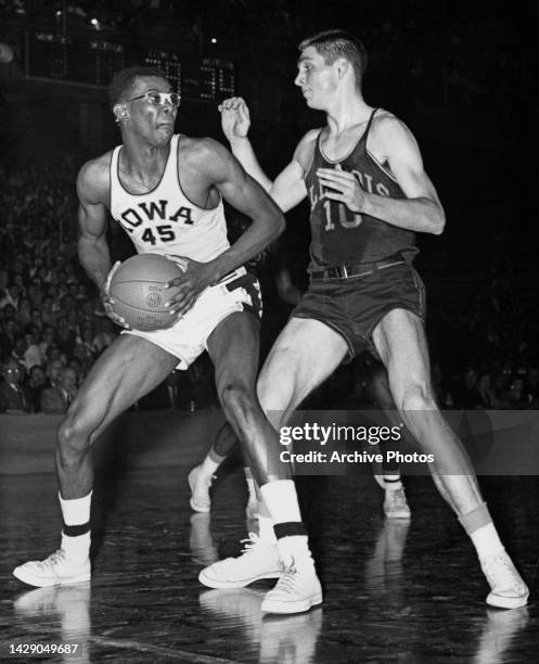 American basketball player Nolden Gentry, of the Iowa Hawkeyes, under pressure from American basketball player John Wessels , of the Illinois...