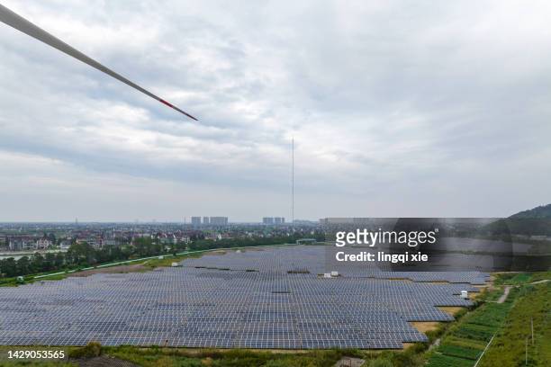 wind turbine blades swipe over solar power plant - zonne eiland stockfoto's en -beelden