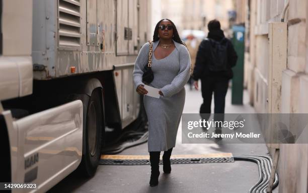 Fashion week guest seen wearing a grey knit dress and a bottega veneta pouch, outside The Row during Paris Fashion Week on September 28, 2022 in...