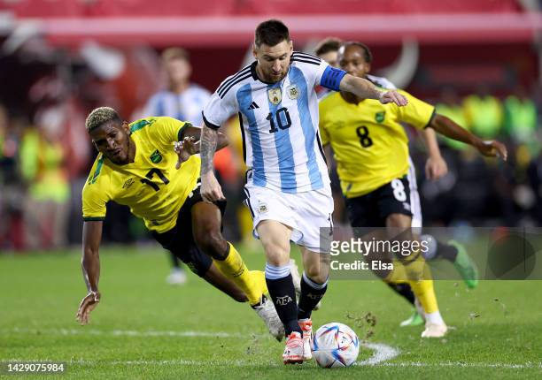 Lionel Messi of Argentina takes the ball as Damion Lowe # of Jamaica defends in the second half at Red Bull Arena on September 27, 2022 in Harrison,...