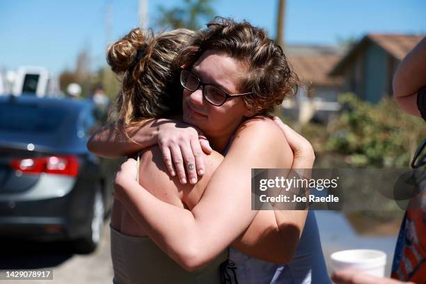 Emily Fisher hugs her neighbor Natalie Lyons after they saw each other when they came to visit what was left of their homes after Hurricane Ian...