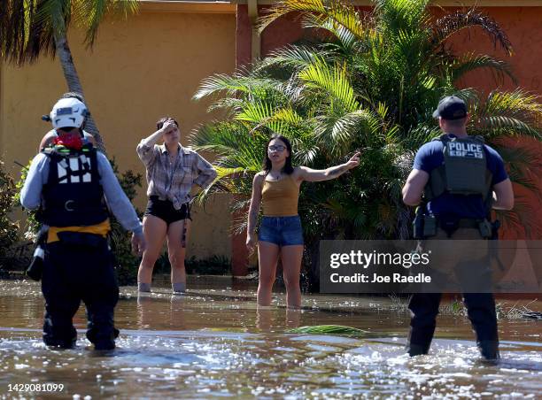 Residents speak with members of the Texas A&M Task Force 1 Search and Rescue team as they look for anyone needing help after Hurricane Ian passed...