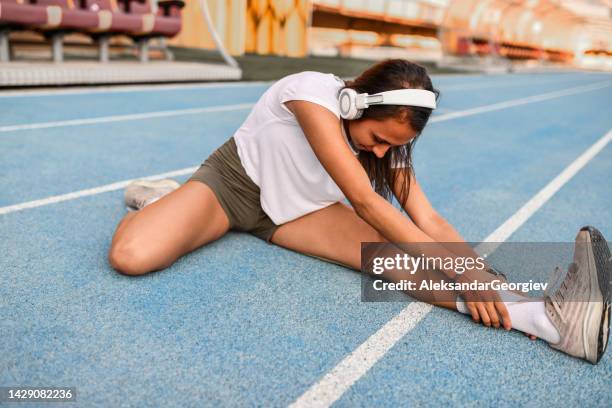 athletic female stretching legs - short track imagens e fotografias de stock