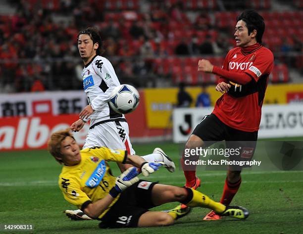 Keiji Tamada of Nagoya Grampus battles for the ball with Lee Ho Seung of Consadole Sapporo during the J.League match between Nagoya Grampus and...
