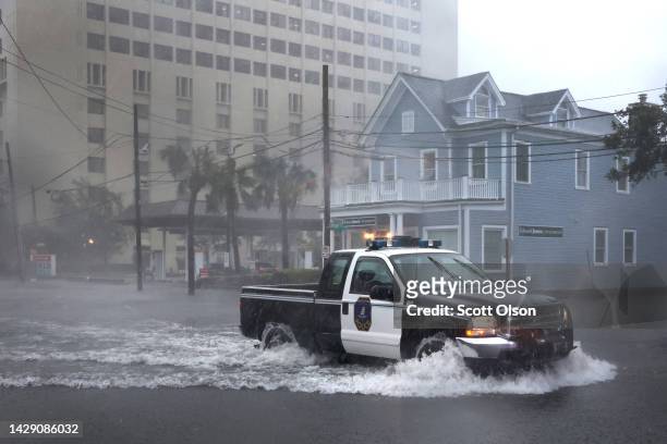 Police vehicle drives down a flooded street as rain from Hurricane Ian drenches the city on September 30, 2022 in Charleston, South Carolina. Ian hit...