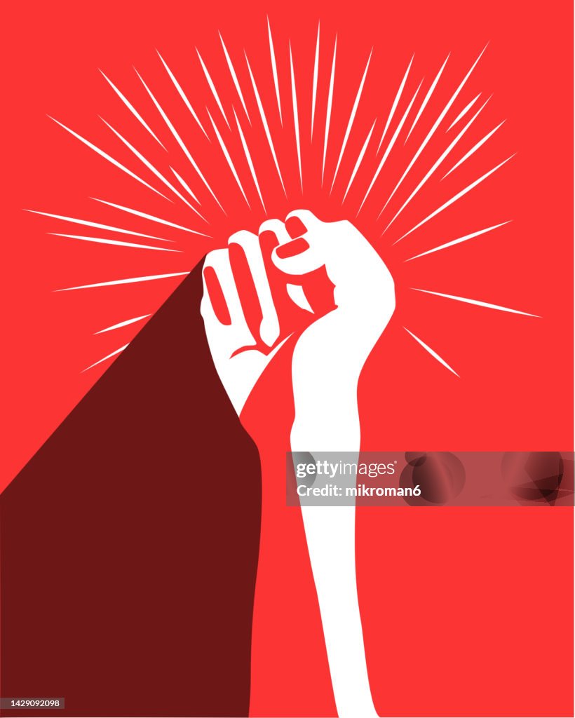 Illustration of a fist risen up on a red background- revolution concept poster