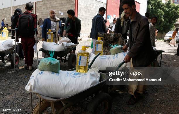 Yemenis who were affected greatly by eight years of conflict, blockade, and economic crisis receive humanitarian aid on September 29 in Sana'a,...