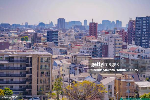 high angle view of buildings in city against sky - ota ward stock-fotos und bilder