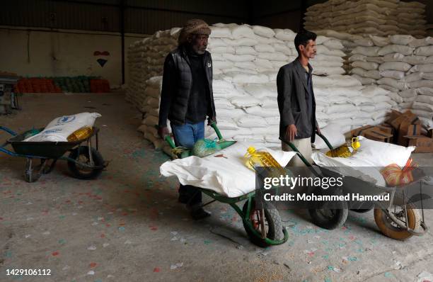 Yemenis who were affected greatly by eight years of conflict, blockade, and economic crisis receive humanitarian aid on September 29 in Sana'a,...