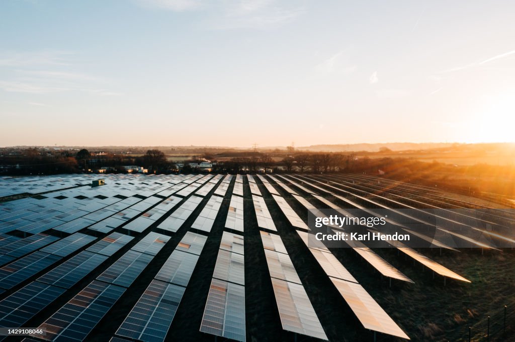 An aerial view of solar panels at sunrise