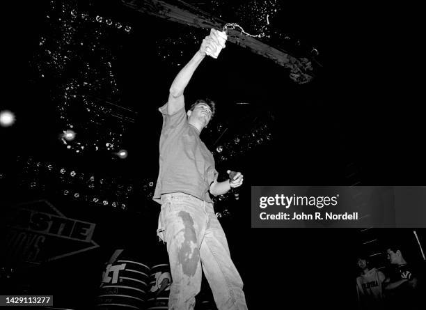 American rapper, bass player and filmmaker Adam "MCA" Yauch , of the American rap rock group Beastie Boys, sings and sprays beer on stage during the...