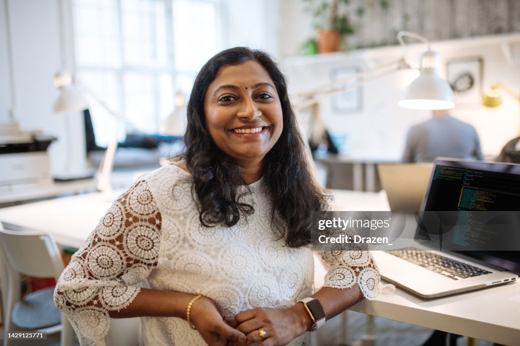 Portrait of mature Indian female employee in office. Indian businesswoman looking at camera