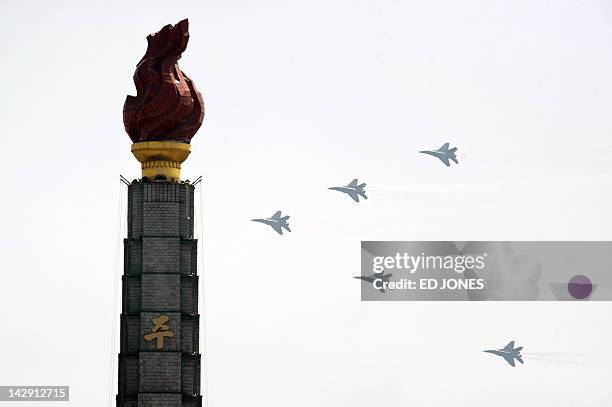 North Korean jets fly past the Juche tower during a military parade in honour of the 100th birthday of the late North Korean leader Kim Il-Sung in...