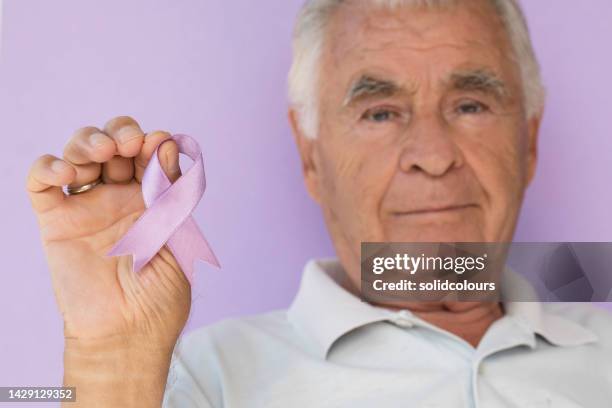 senior man purple awareness ribbon - social awareness symbol stock pictures, royalty-free photos & images