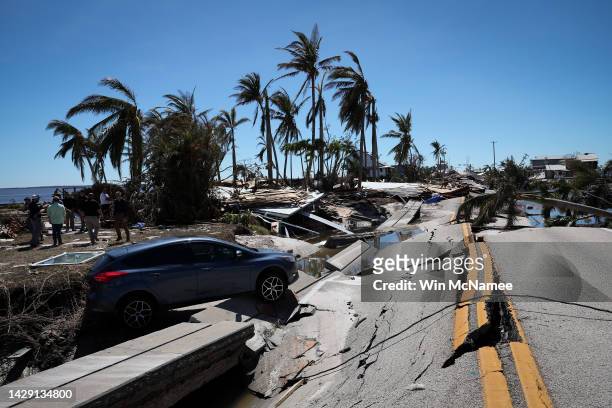 The wreckage o a car teeters on a buckled roadway in the wake of Hurricane Ian on September 30, 2022 in Matlacha, Florida. The hurricane brought high...