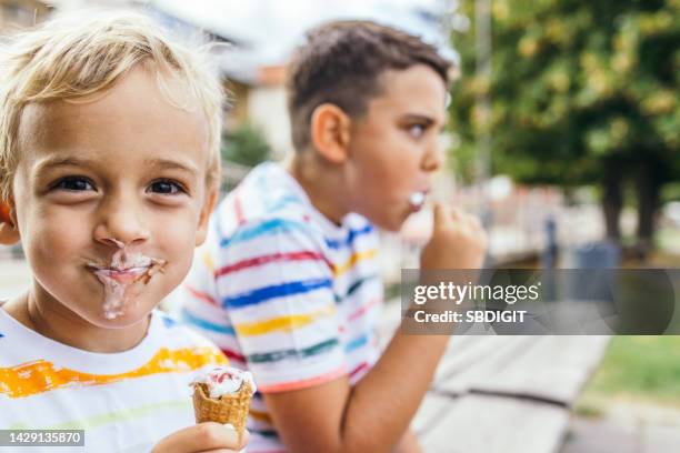 messy caucasian toddler boy eating ice cream - kid eating ice cream stockfoto's en -beelden