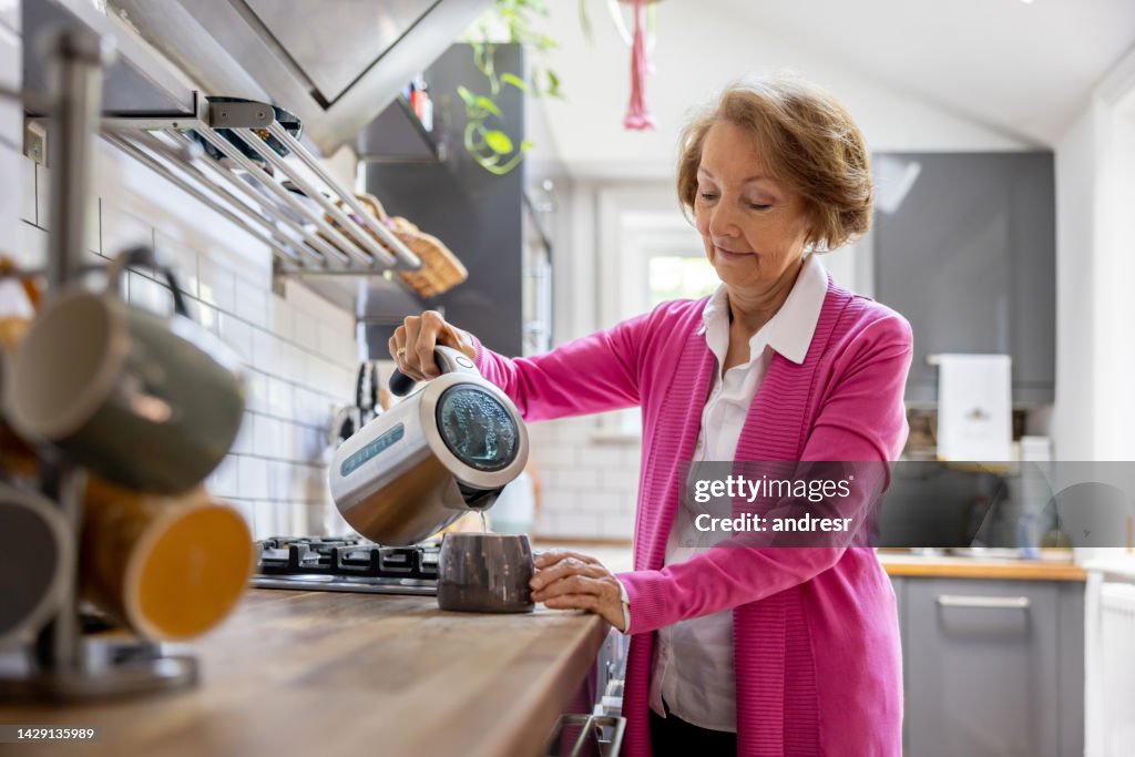 Mulher idosa fazendo uma xícara de chá