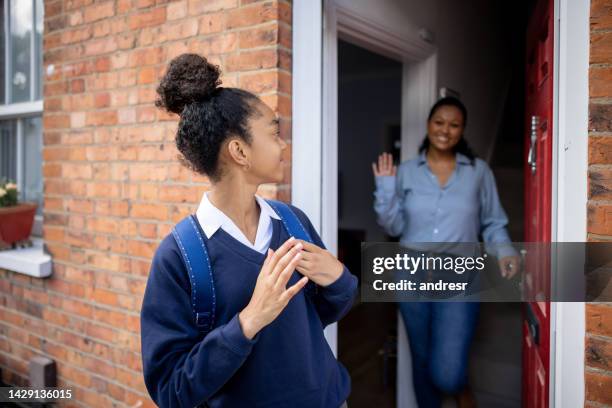 girl going to school and waving goodbye to her mother - leaving school imagens e fotografias de stock
