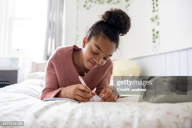 happy teenager at home doing her homework in her bedroom - 10 11 anos imagens e fotografias de stock