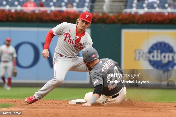 Bryson Stott of the Philadelphia Phillies tags out trying to steal second in the Lane Thomas of the Washington Nationals trying to steal second in...