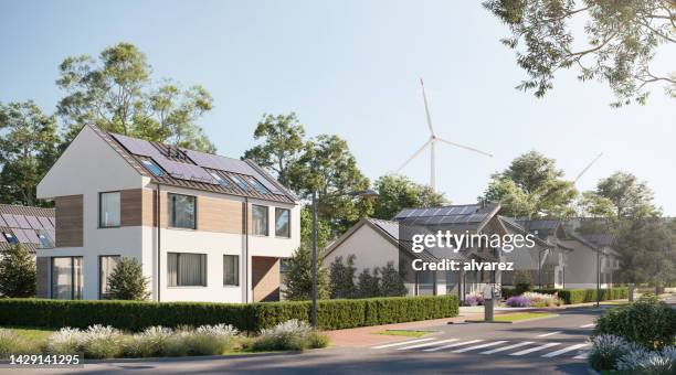 digitale renderings einer nachhaltigen stadt mit sonnenkollektoren und windenergie - geplante wohnsiedlung stock-fotos und bilder