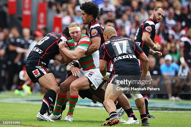 Michael Crocker of the Rabbitohs is brought down by Sione Lousi and Elijah Taylor of the Warriors during the round seven NRL match between the New...
