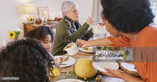 thanksgiving, lunch and family serving food at the table in the dining room for a celebration. luxury holiday feast, festive pumpkin decorations and people sitting and eating together at home. - cooked turkey white plate stockfoto's en -beelden