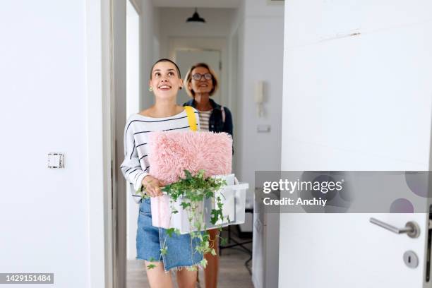 daughter and mother carrying boxes into a new residence - parent student stock pictures, royalty-free photos & images