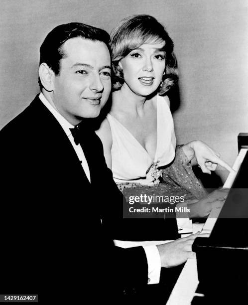 German-American pianist, composer, and conductor André Previn , plays his piano with American comedienne, actress, singer and businesswoman, Edie...