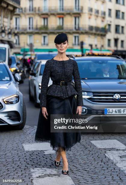 Sabina Jakubowicz wears beret with net, tailored jumper, laced skirt in black, Dior bag, heels outside Giambattista Valli during Paris Fashion Week -...