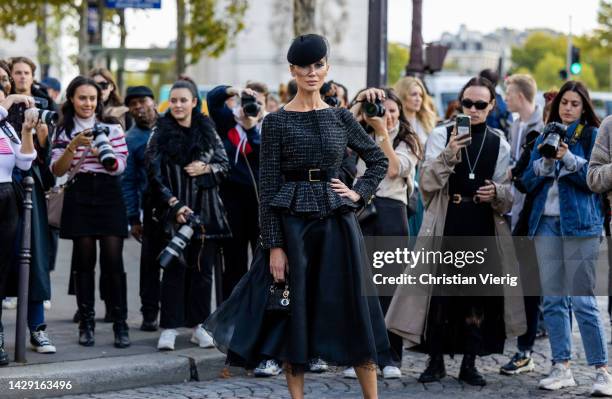 Sabina Jakubowicz wears beret with net, tailored jumper, laced skirt in black, Dior bag, heels outside Giambattista Valli during Paris Fashion Week -...